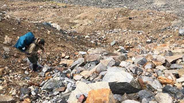 Image of backpacker on rocky terrain.